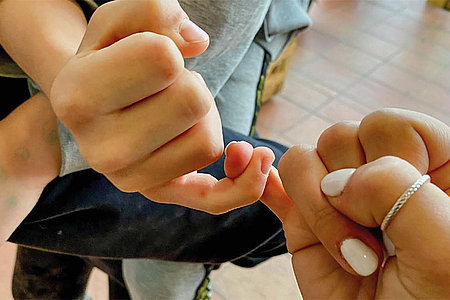 Kleiner Finger von Kind und Erwachsenem miteinander verhakt