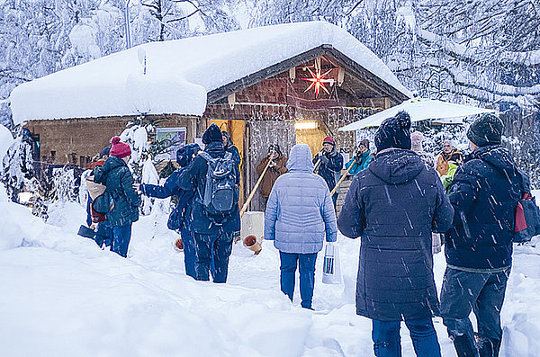 Besucher*innen des Herzogsägmühler Weihnachtsmnarktes bei Schnee.