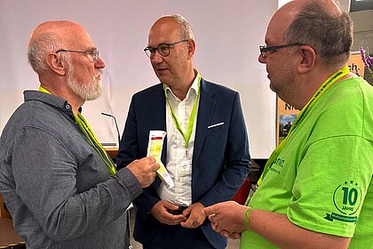 Diakonie-Präsident Rüdiger Schuch (Mitte) im Gespräch mit Organisatoren des Wohnungslosentreffens.