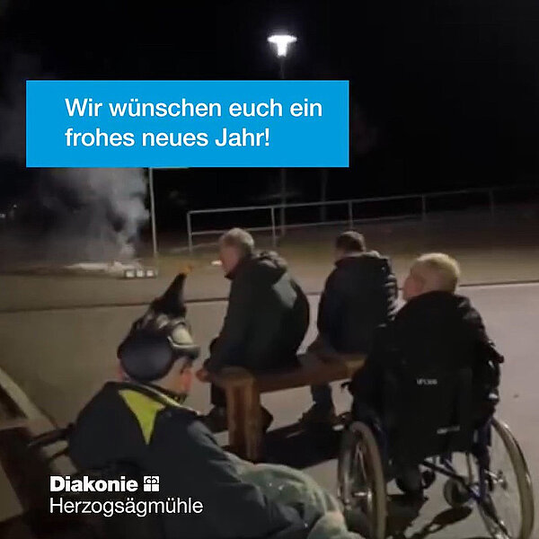 Die Bewohner*innen wünschen ein frohes neues Jahr. Eine Gruppe schaut auf der Straße Silvesterknaller an.