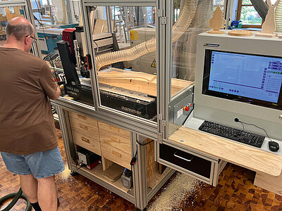 Ein Arbeiter bedient eine Holzbearbeitungsmaschine